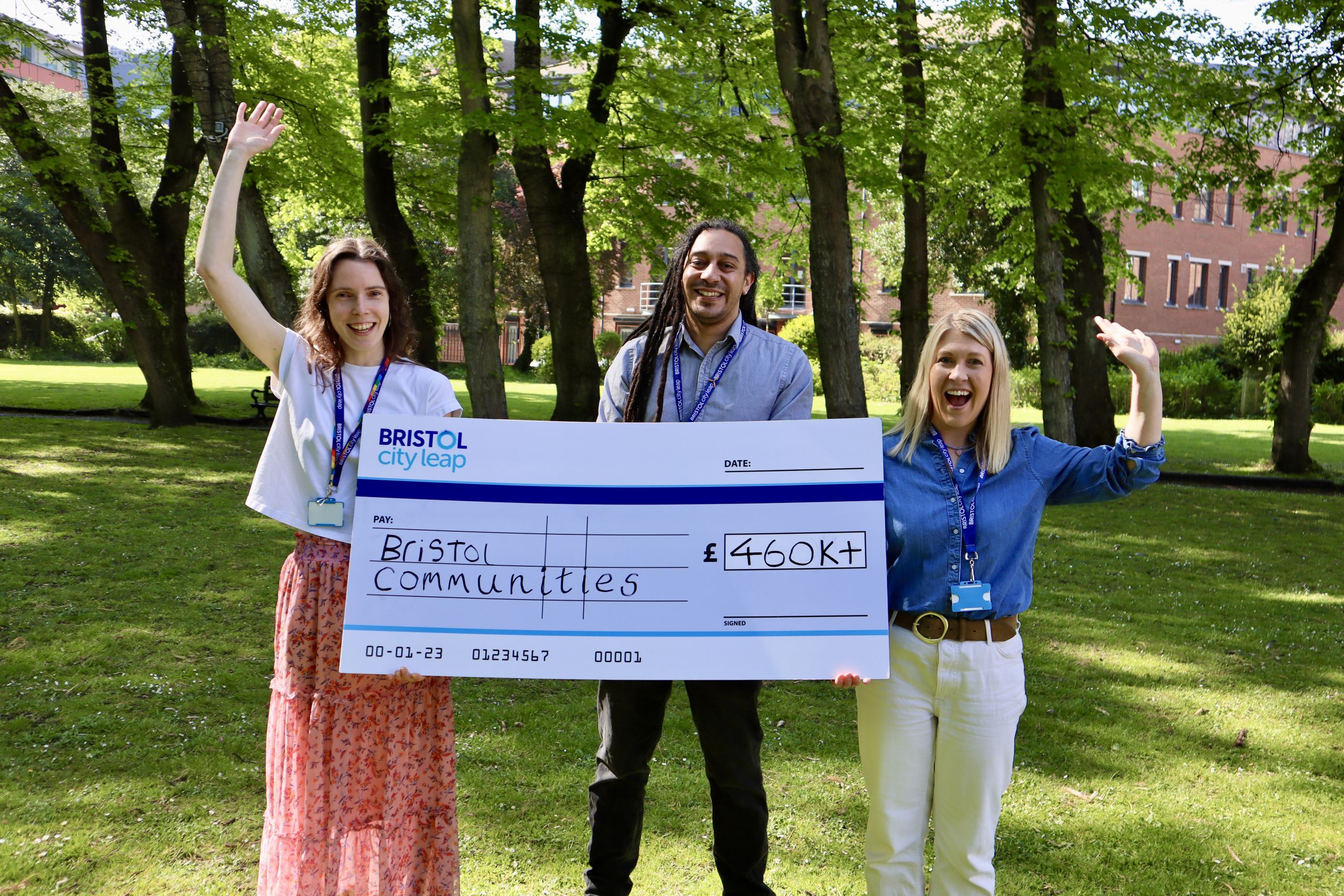 Three representatives from Bristol City Leap celebrate the latest round of funding for their Community Energy Fund, which has now surpassed £460,000 in awarded grants. They hold a giant novelty cheque to commemorate the occasion, showcasing their commitment to supporting community-led initiatives for a sustainable future.